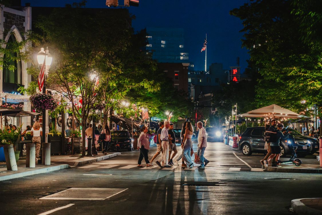 A photo of Bedford Street at night with people crossing the street